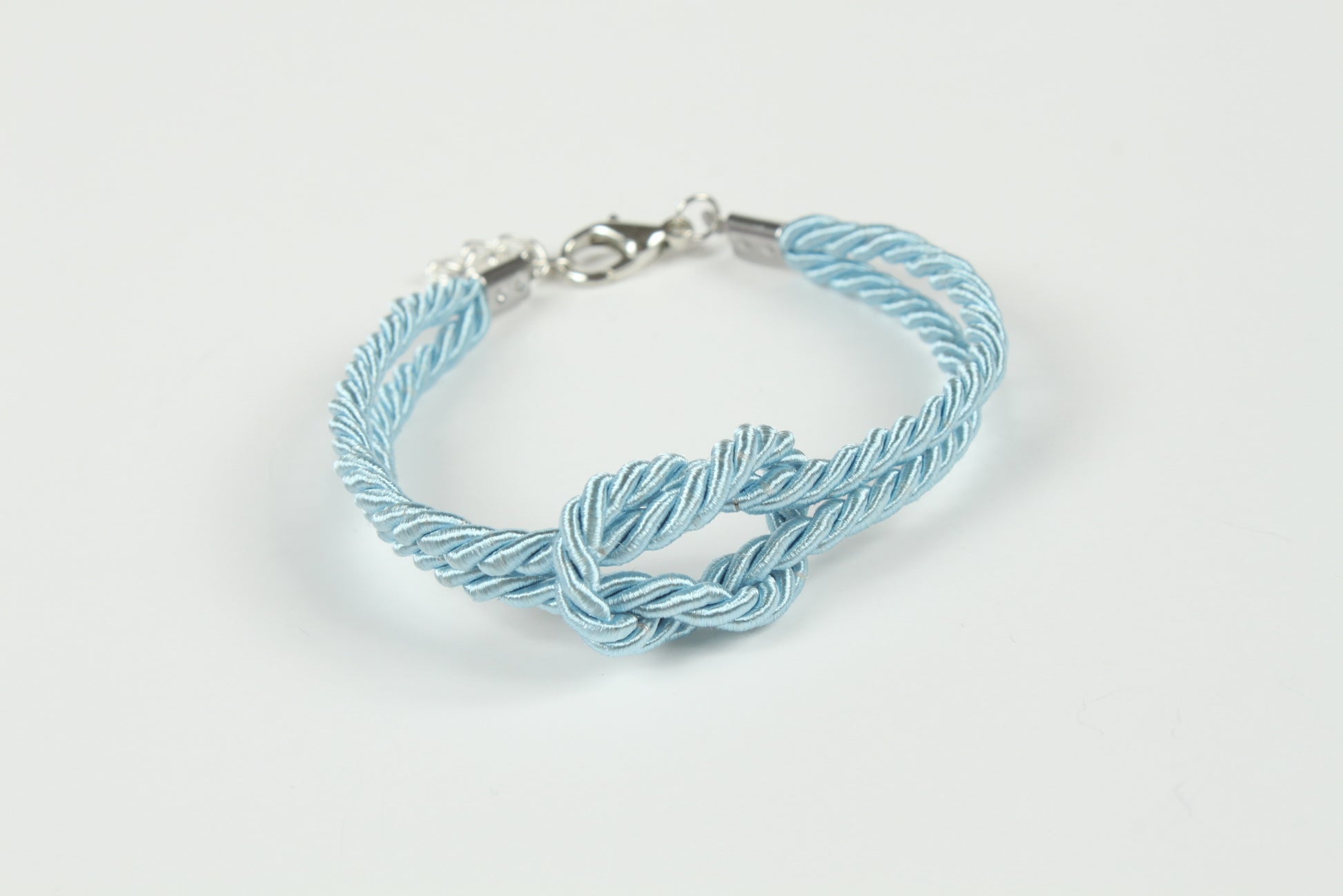 Kink-friendly blue bracelet with twisted cords and central knot