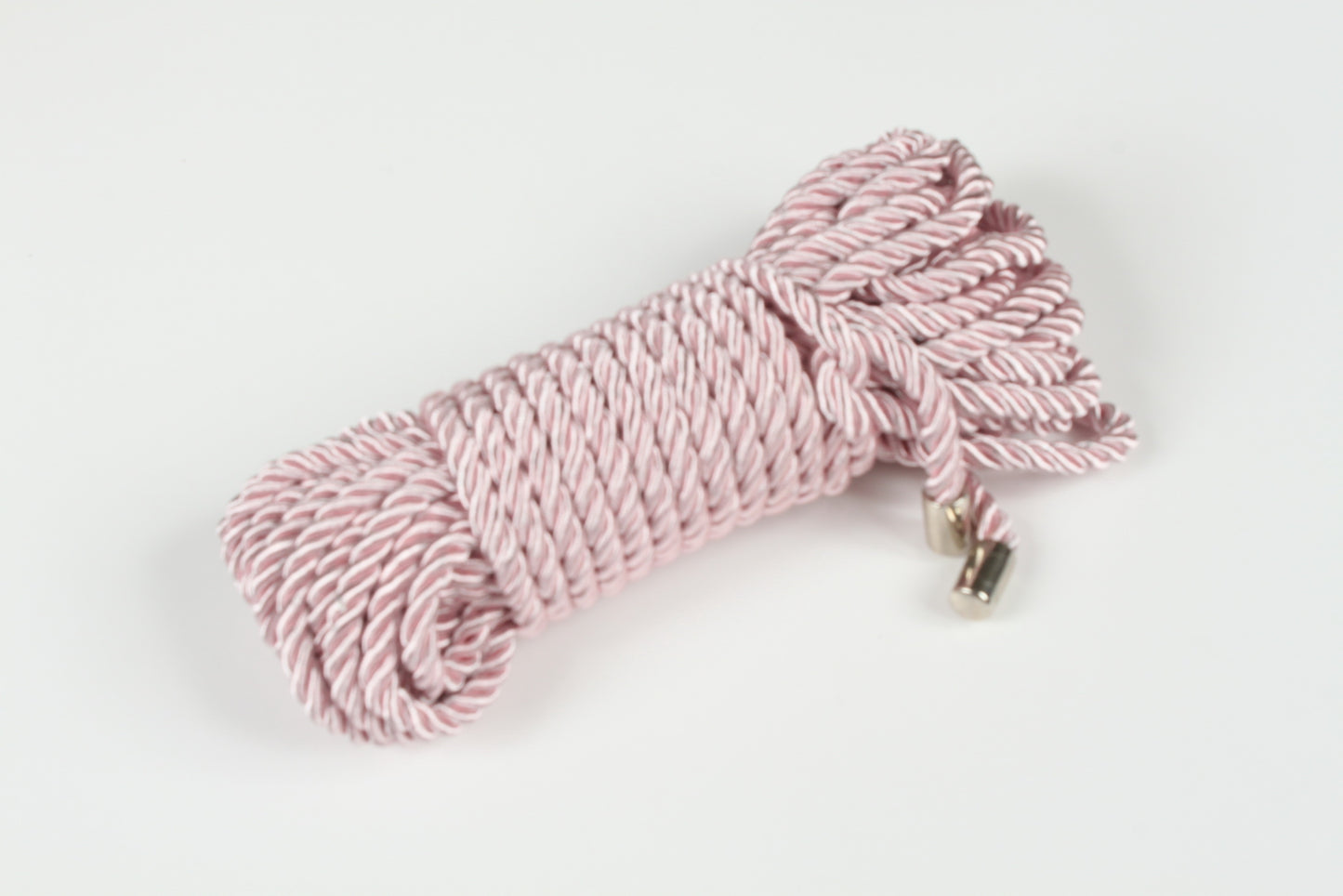 Soft pink BDSM rope with satin finish and metal-tipped ends