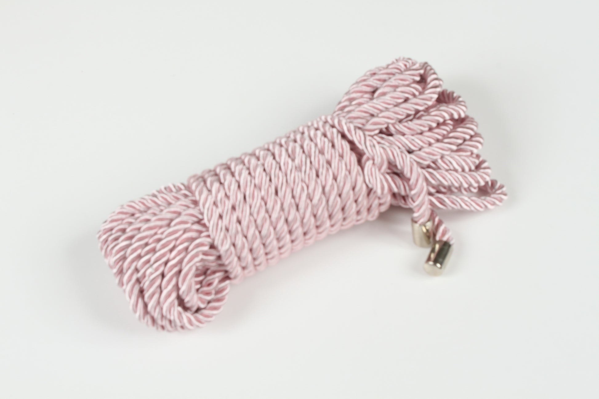 Soft pink BDSM rope with satin finish and metal-tipped ends